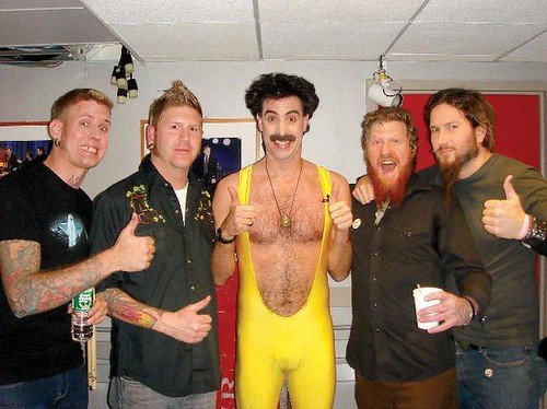 Mastodon band members standing alongside Sacha Baron Cohen dressed as Borat.